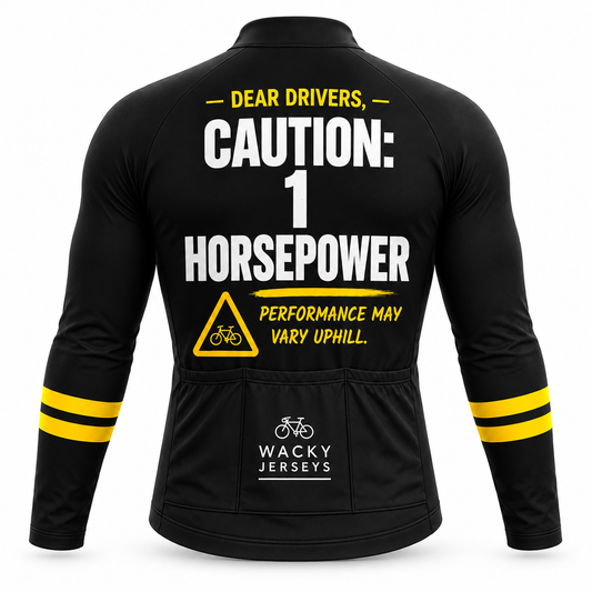 Black long-sleeve cycling jersey shown from the back with bold white and yellow text reading 'DEAR DRIVERS, CAUTION: 1 HORSEPOWER' and 'PERFORMANCE MAY VARY UPHILL.' A yellow warning triangle with a bicycle symbol appears below.