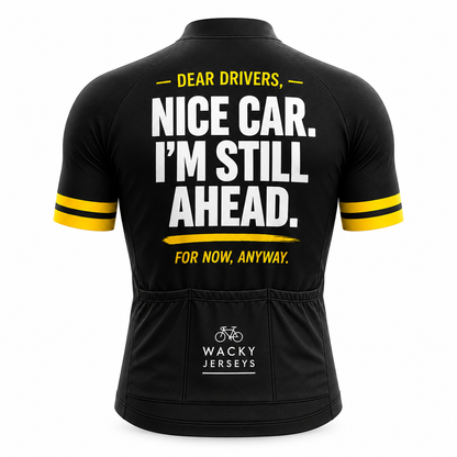 Black short-sleeve cycling jersey shown from the back with bold white text reading 'NICE CAR. I'M STILL AHEAD.