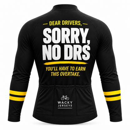 Black long-sleeve cycling jersey shown from the back with bold white and yellow text reading 'DEAR DRIVERS, SORRY, NO DRS YOU'LL HAVE TO EARN THIS OVERTAKE.' and a visible 'WACKY JERSEYS' logo near the lower back.